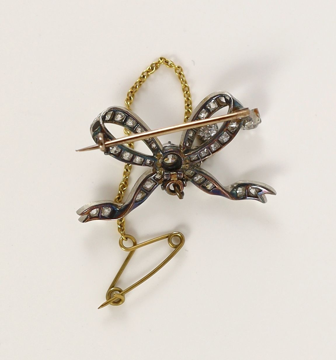 A Victorian gold, silver and diamond cluster set ribbon bow brooch, with two diamond set graduated drops